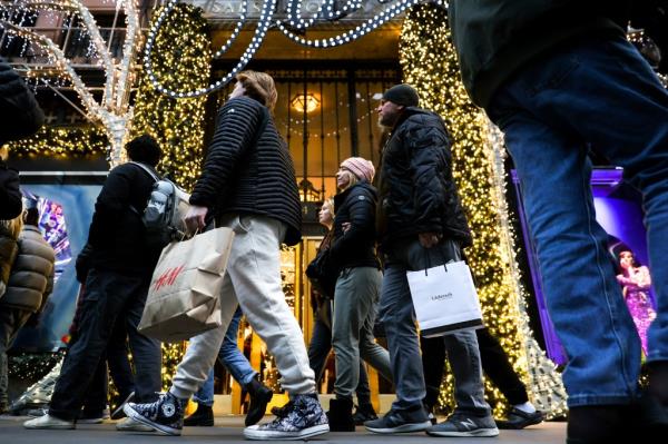 Shoppers carrying shopping bags down Fifth Avenue on Dec. 19, 2022.